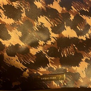 Designed with high-quality perforated material and gold accents on the zippers.